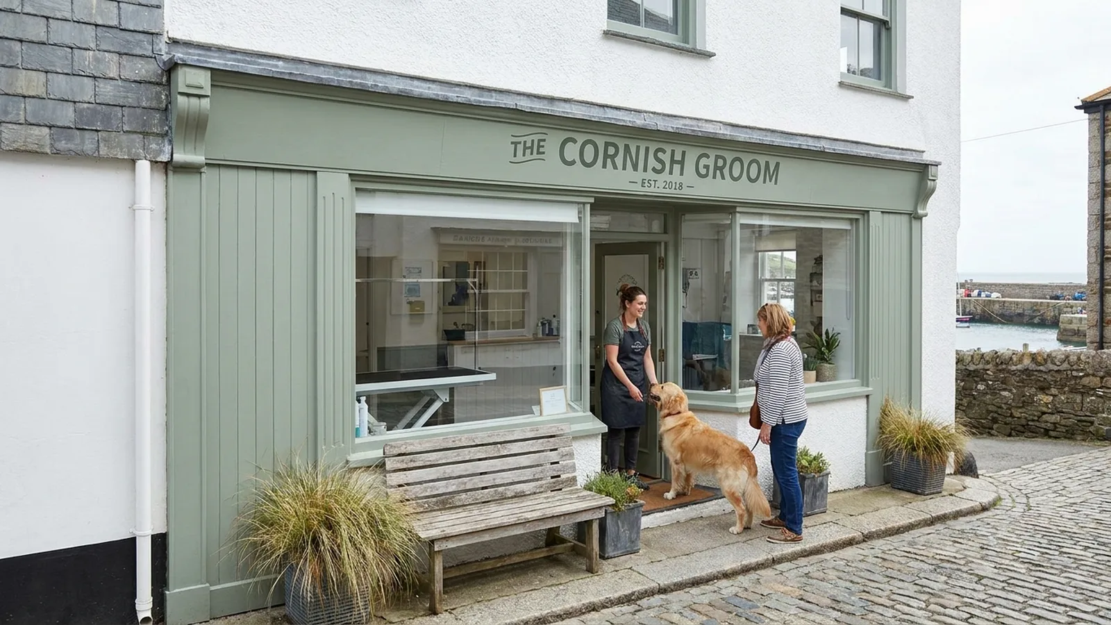 Dog groomer welcoming a customer at a Cornwall harbourside business